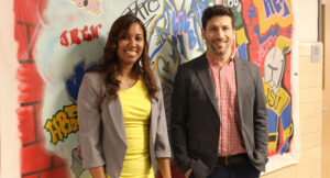 Midaly Carrasquillo and Adam Saltsman in front of a mural outside the UAI office
