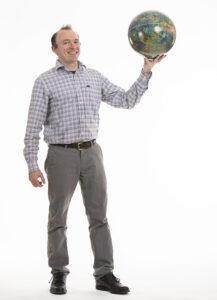 Ian Stephens holding a globe.