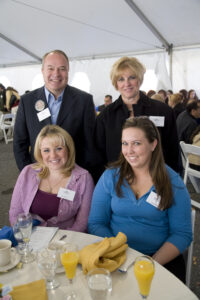 Two men and two women pose for a photograph at a table during an event.