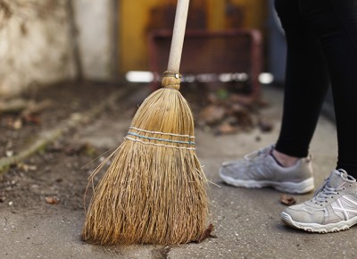 image of person sweeping sidewalk