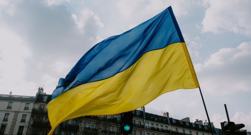 The Ukrainian flag flutters in the breeze in front of a blue sky with clouds