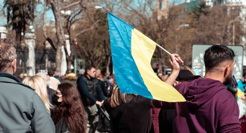 A man in a hoodie holding a Ukraine flag