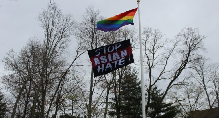 The black Stop Asian Hate flag flies below the Pride flag on a flagpole