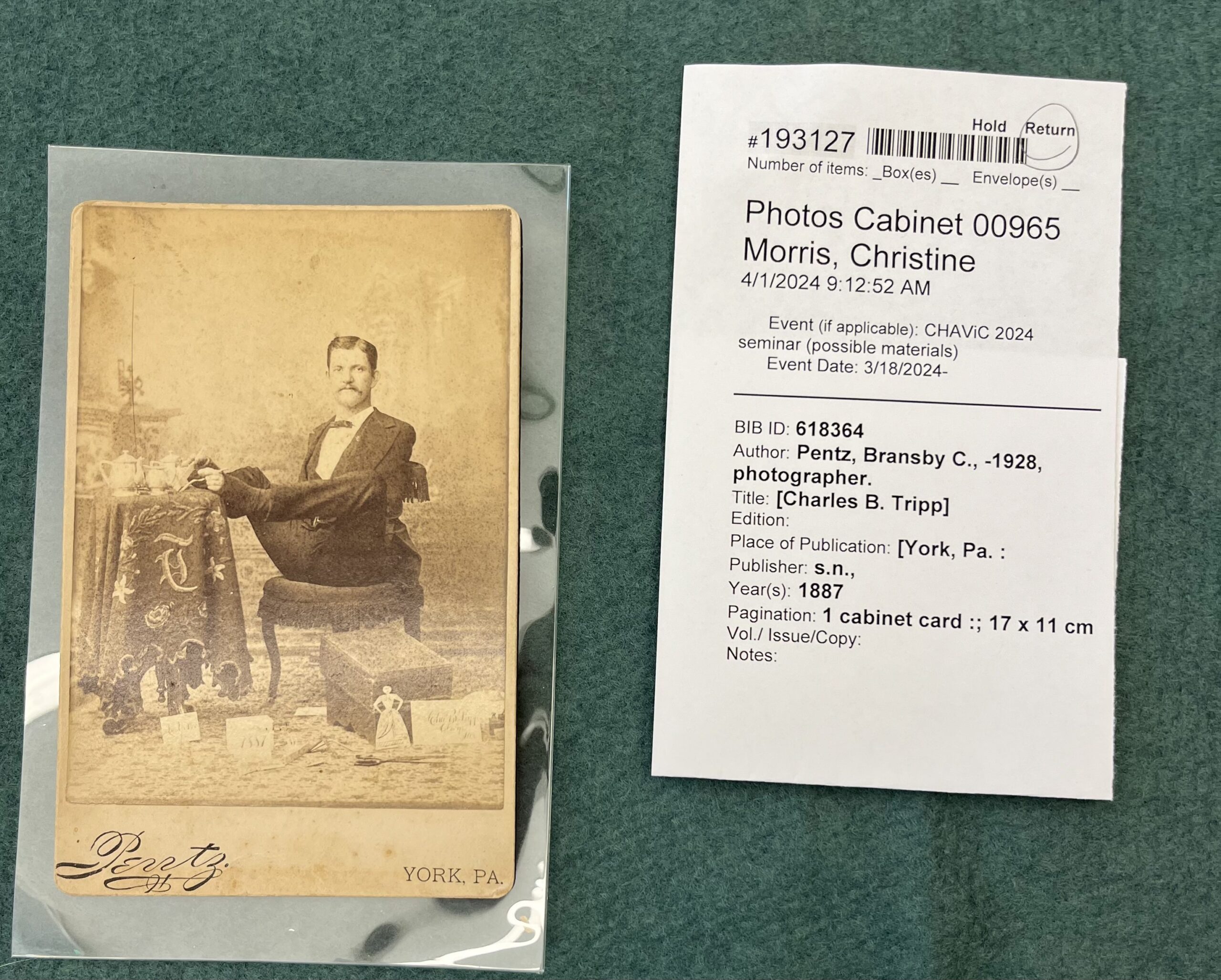A photo of Charles B. Tripp, a man with no arms, sitting at a table and using his feet to handle a teacup