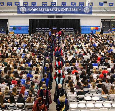 Faculty in full regalia process into the gym for Convocation
