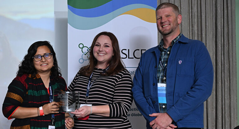 Nafisa Tanjeem standing with IARSLCE officials as she receives her award